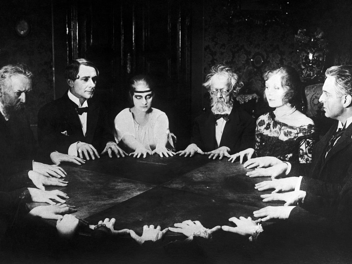 historic picture of people sitting at a table conducting a seance